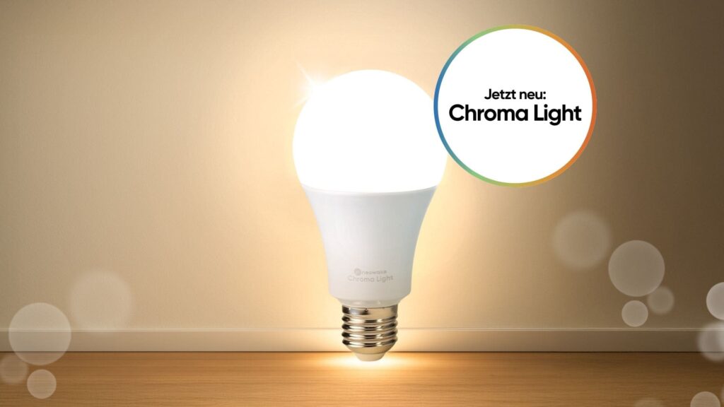 Leuchtende LED-Lampe auf Holzuntergrund mit dem Hinweis „Jetzt neu: Chroma Light“. Die weiße LED-Glühbirne von neowake® strahlt helles, gleichmäßiges Licht aus – Symbol für die neue LED Vollspektrum Glühbirne Chroma Light